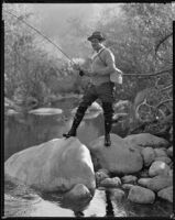 Jack Holt, actor, fishing in a stream, perhaps for a Silver Screen magazine feature, 1927-1939
