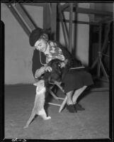 Helen Westley, actress, playing with a cat on the set of I'll Take Romance, 1937