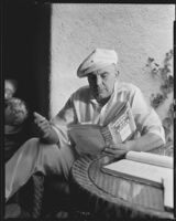 James Cruze, director, reading the book Washington Merry-Go-Round, circa 1932