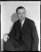Man wearing a suit and tie and posing with his legs crossed, circa 1926-1939