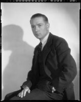 Man wearing a suit and tie and posing with his hand in his pocket, circa 1926-1939