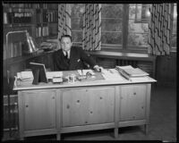 Unidentfied Columbia Pictures employee sitting at his desk, 1934