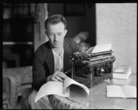 Eugene Thackrey, screenwriter, sitting a table with a typewriter, a screenplay, and the book Washington Merry-Go-Round, circa 1932