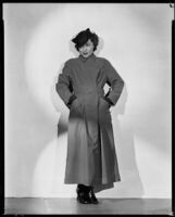 Woman wearing a trench coat and hat, 1930s
