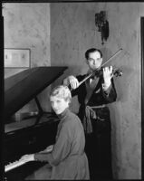 Joseph Schildkraut, actor, playing a violin while his wife, Marie, plays a piano, circa 1934