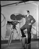 Albert Rogell, director, standing with a film camera, circa 1929-1938