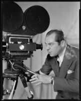 Albert Rogell, director, looking into a film camera, circa 1929-1938