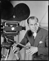 Albert Rogell, director, with a film camera, circa 1929-1938