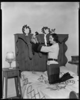 Geneva Mitchell, actress, hanging stockings on a headboard, circa 1931-1936