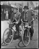 Charlie Murray and George Sidney, actors, riding bicycles, circa 1930-1934