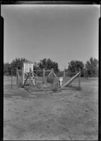 Planting tank, water spigot and equipment in a fenced off plot in a landscape, southern California, circa 1942
