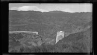 Distant view towards the largest remaining portion of the Saint Francis Dam after its collapse and the canyon beyond, San Francisquito Canyon (Calif.), 1928
