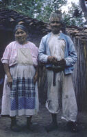 Mexico - Elder man and woman standing in front of small dwelling, between 1960-1964