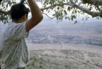 Mexico (Jalisco) - Young man on hill with small town in distance, between 1960-1964