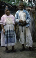 Mexico - Elder man and woman standing in front of small dwelling, between 1960-1964