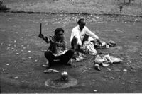 Two wandering musicians (baton, metal rings) seated on the ground, Lonāvale (India), 1963