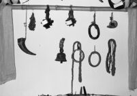 Board with small instruments, including an animal horn, a bell, a taal set and metal rings, India, 1963-1964