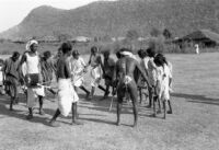 Koyā people dance with a ḍolu musician and two men with hunting bows, Nehrunagar (India), 1963