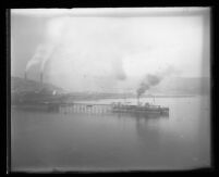 A large steam ship is docked in a harbor.